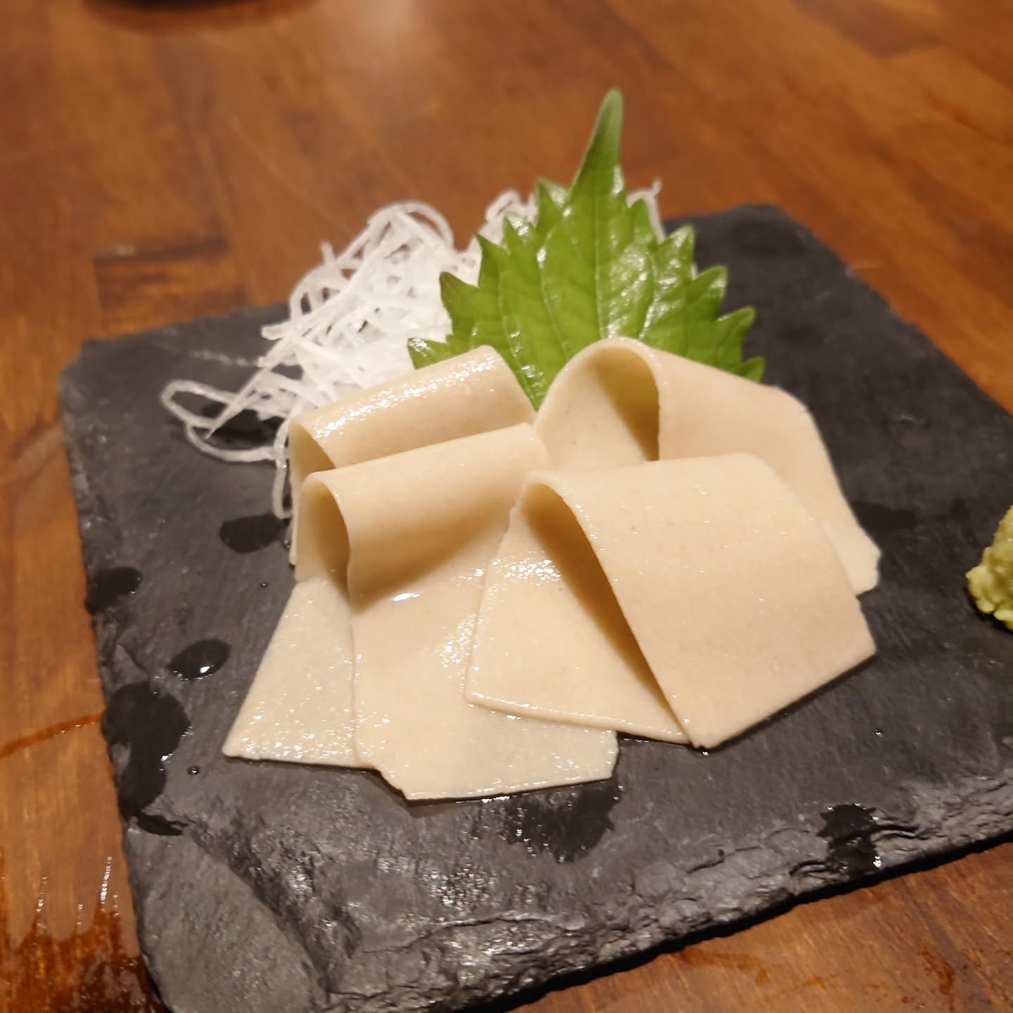 雨季後期の大雨、膝や腰がギシギシ軋む音立てて、KaneHisaです

お刺身蕎麦140B
よく、これどんなのですか？、と聞かれるメニュー
シート状に延して切った十割蕎麦(!!)をお刺身のようにわさび醤油でいただく、変わり種
普段のツルツル喉越しなお蕎麦とは一味違う食感を楽しめる一品どす
これを作るときは一緒に細打ち十割蕎麦もできちゃうので、今日こられる方限定でご案内できますよ〜

#KaneHisa
#手打ち蕎麦 
#bangkok 
#โซบะ 
#お刺身蕎麦
#十割蕎麦