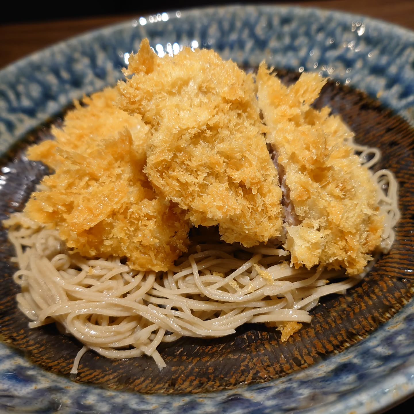 炭火を見つめているとあくびがでてくる、KaneHisaです

とんかつぶっかけ蕎麦340B
冷たく締めた麺に冷えたつゆをぶっかけるスタイル、ぶっかけ蕎麦シリーズ
そこに揚げたてとんかつを載せてしまうこのメニュー
とんかつのお肉をしれっとヒレ肉に変えてから写真撮り忘れてて、昨日撮ったから掲載
その都度揚げる、生パン粉にこだわる、ラードで揚げて薫り良く、ヒレ肉で柔らか食感
何気につゆとの相性も蕎麦との食べ合わせも良きな一品
騙されたと思って頼んでミソ…

#KaneHisa
#手打ち蕎麦 
#bangkok 
#โซบะ 
#とんかつぶっかけ蕎麦

ちなみにあくびした後力抜けて、膝からガクガク崩れ落ちることしばしば中の人