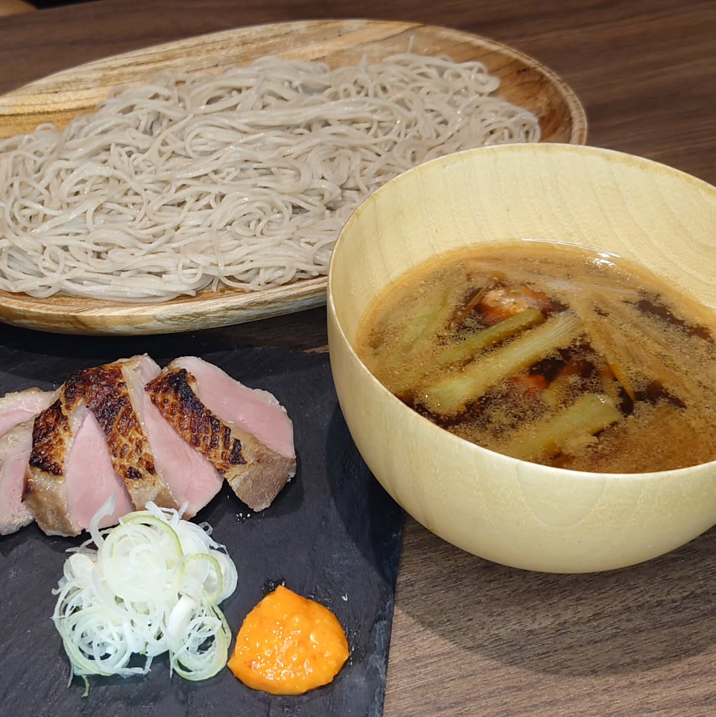 毎日雨が降るんじゃないかとドキがムネムネ、KaneHisaです

鴨南蛮つけ蕎麦360B
元々鴨か苦手だった中の人、低温調理というものに出会った結果出来上がった蕎麦屋定番メニュー
加熱しすぎると固くなるのを低温調理で柔らかく、つゆで煮込まず別皿提供することで課題を解決してみた
付け合わせる薬味は自家製柚子胡椒、色がオレンジなのは黄色の柚子皮と赤い唐辛子(タイのは辛い🌶️)だから
つゆの中には鴨つくねが入っているよ

#KaneHisa 
#手打ち蕎麦 
#bangkok 
#โซบะ 
#鴨南蛮つけ蕎麦 

雨降って今日はお客様来ないかな、って思ってると意外と来ていただけるし
今日は晴れだ！というのにめちゃ暇になったり…
もう天気は気にしない方が良いのかな？