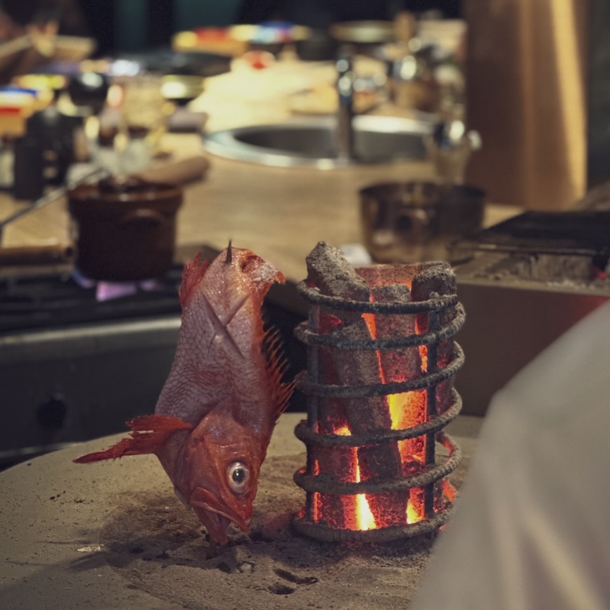 【อิโรริยากิ】

อิโรริยากิเป็นหนึ่งในวิธีการปรุงอาหารแบบดั้งเดิมของญี่ปุ่น
ใช้เตาอิโรริที่ล้อมรอบด้วยถ่านไม้
อาศัยความร้อนจาก รังสีอินฟราเรด
ค่อย ๆ ย่างอย่างพิถีพิถัน ใช้เวลาเพื่อให้ความร้อนซึมเข้าเนื้ออย่างสม่ำเสมอ

การย่างโดยไม่โดนไฟโดยตรงมากเกินไป
ทำให้ผิวด้านนอกหอมกรอบ
ด้านในนุ่ม ชุ่มฉ่ำ
ช่วยเก็บกักความชุ่มชื้นและรสอูมามิของวัตถุดิบ
ขณะเดียวกัน ไขมันส่วนเกินจะค่อย ๆ หยดออกตามธรรมชาติ

ที่ AOKI
เราควบคุมระดับไฟของถ่านอย่างละเอียด
ย่างทีละจาน ด้วยระยะและเวลาที่เหมาะสมที่สุด
เพื่อดึงรสชาติแท้ของปลา เนื้อ และผักออกมาอย่างเต็มที่

【囲炉裏焼き】

囲炉裏焼きは、日本の伝統的な調理法のひとつです。
炭火を囲む囲炉裏で、遠赤外線の熱を使い、時間をかけてじっくり火を通します。

直火に当てすぎることなく焼き上げることで、
表面は香ばしく、中はふっくらジューシーに仕上がるのが特徴です。
素材の水分と旨みを閉じ込め、余分な脂は自然に落ち、
魚・肉・野菜それぞれの本来の味わいを最大限に引き出します。

AOKIでは、炭の火加減を見極めながら、
一品一品、最適な距離と時間で丁寧に焼き上げています。

#bangkokjapanesefood 
#bangkokfoodies 
#bangkokseafood 
#bangkokrestaurant 
#bangkokjapaneserestaurant